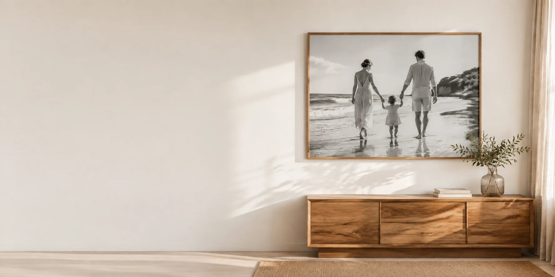 Personal family photograph printed on canvas in an oak frame above a light wood console